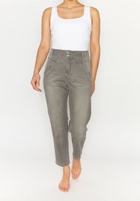 Grå högmidjade momjeans med avslappnad passform, som har framfickor, knäppning och subtila blekningar. Bärs med en vit linne.