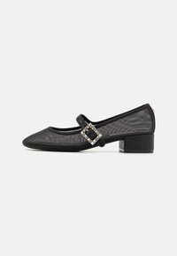 Black mesh low-heeled shoes feature a rounded toe with a decorative buckle strap. The design includes a textured finish and subtle accents.