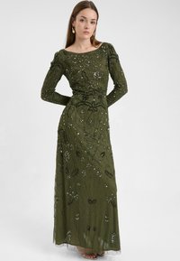 Abito lungo verde oliva con un corpetto aderente, maniche lunghe, intricate ricami in perline e fiori, e una gonna fluida e trasparente.