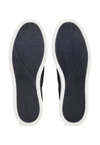 Paire de semelles de chaussures noires avec bords blancs montrant un motif ondulé et le logo "Tommy Hilfiger" sur fond blanc.