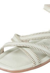 Light green leather sandal with crisscross straps, textured stitching, and a flat sole. Open-toe design enhances breathability.