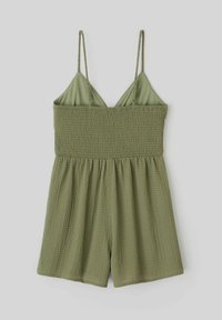 Combinaison olive verte avec bretelles spaghetti, corsage froncé et tissu texturé. Le short a une coupe ample, favorisant le confort et la respirabilité.