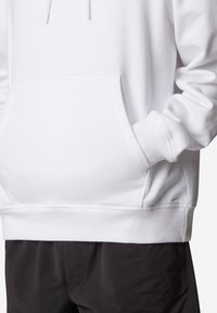 Sudadera blanca de algodón con un bolsillo canguro, puños acanalados y dobladillo. La tela es suave y texturada, con cordones para ajuste.