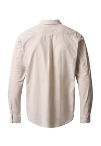 Bēšas krāsas garām piedurknēm krekls ar pogām, redzams no aizmugures, ar centrālu kroku un aizpogātiem aprocēm.