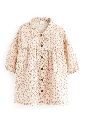 Bluse mit Knöpfen und floralem Muster in Creme mit pinken Blumen. Verfügt über einen Kragen, eine geraffte Taille, zwei Fronttaschen und elastische Ärmel.