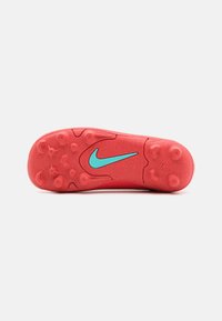 Červená guma na podrážke športovej obuvi s textúrovaným povrchom, s modrým logom Nike a strategicky umiestnenými kolíkmi pre trakciu.