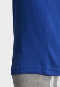 Short-sleeve blue T-shirt, made of soft cotton, featuring a round neckline and straight hem. Fabric appears smooth with no visible patterns.