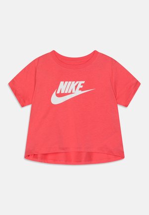 T-shirt court corail à manches courtes avec col rond et logo Nike blanc avec le swoosh sur le devant, posé à plat sur un fond blanc.