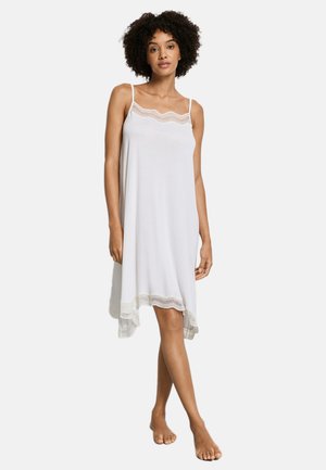 Wit mouwloos nachthemd met kanten boord langs de halslijn en zoom. Zachte stof, losse pasvorm en een knie-lengte ontwerp.