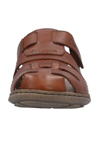 Brown leather sandal with open front and side, adjustable strap, textured sole, and woven design details.