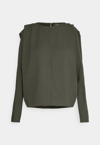 Blouse vert olive foncé à manches longues avec un col rond et une couture centrale, présentée à plat sur un fond clair.