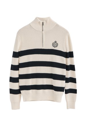 Pull crème à côtes avec des rayures horizontales bleu marine, col zippé quart, et logo brodé sur la poitrine. Texture douce et design décontracté.