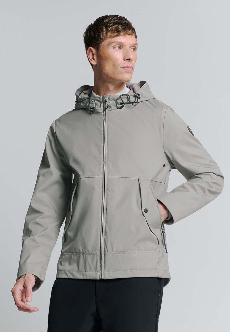 Lichte, grijze, waterdichte jas met een capuchon, verstelbare koordjes, meerdere zakken en een ritssluiting aan de voorkant.