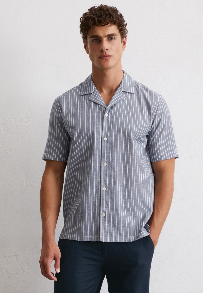 Short-sleeved button-up shirt in blue and white vertical stripes, featuring a notched collar and smooth fabric.