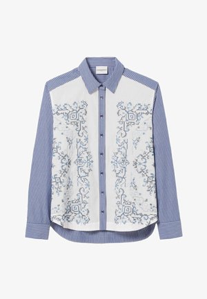Camisa abotonada con rayas verticales azules y blancas, que presenta un bordado geométrico simétrico en azul y negro en los paneles frontales y el cuello.