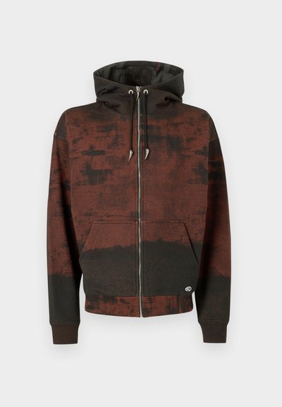 Hoodie com fecho castanho e preto, com cordões e bolsos frontais, apresentando um padrão manchado e desbotado e um pequeno logo perto da bainha.