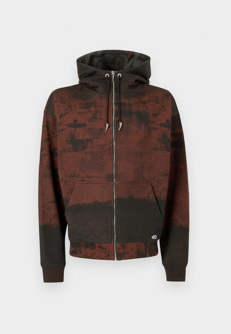 Brun og sort zip-up hoodie med snore og forlommer, der har et marmor mønster med falmede nuancer og et lille logo nær kanten.