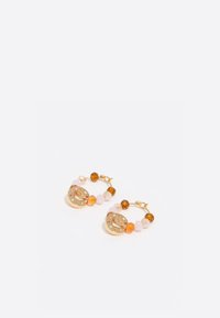 Pendientes de aro dorados con colgantes redondos que presentan acentos numéricos, adornados con cuentas naranjas, marrones y rosas en una variedad de tamaños.