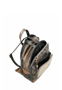 Pequeña mochila con patrones florales en negro y beige, múltiples compartimentos con cremallera y correas de hombro ajustables.