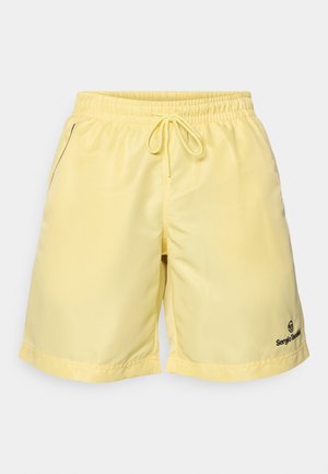 Dzelteni peldbikses, kas izgatavotas no viegla materiāla, ar elastīgu jostu ar šnūri, sānu kabatām un logotipu apakšējā malā.