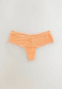 Lace thong in een zachte perzikkleur met een bloemmotief aan de tailleband; beschikt over een glad, naadloos lichaam en een short-style snit.