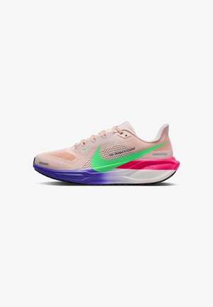 Chaussure de course Nike rose clair avec un swoosh vert, des accents violets et roses sur la semelle, et un texte noir sur le panneau latéral en mesh.