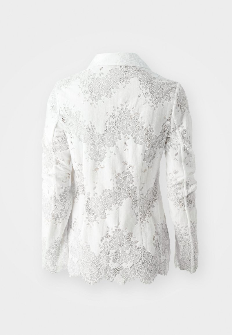 Weiße Spitzenjacke mit langen Ärmeln, die über florale Muster, strukturierte Spitzenverzierungen und ein Kragenformat verfügt. Glattes Material unter der Spitze.