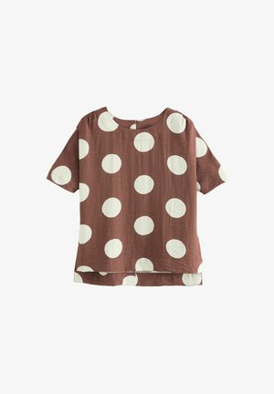 Short-sleeve, brown top with large white polka dots. Features a round neck and a curved hem. Made from lightweight fabric.