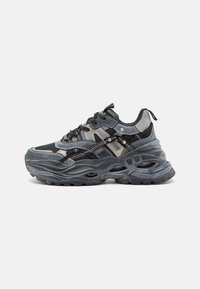 Black and gray athletic shoes with mesh and synthetic upper, prominent wavy sole, reflective accents, and multi-layered design.