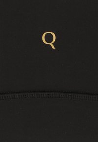 Zwart stof met een gladde textuur en een gouden "Q"-logo. Eenvoudig ontwerp met minimale stikseldetails en geen extra patronen.