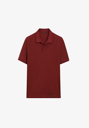 Red polo shirt made of textured fabric. Features a collared neckline and short sleeves, with a two-button placket.