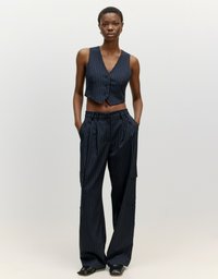 Navy-gestreifter, taillierter Weste mit Knöpfen, kombiniert mit weit geschnittenen, gestreiften Hosen mit Seiten Taschen und einer glatten Textur.