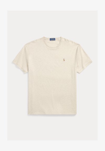 Béžové bavlněné tričko s krátkým rukávem a kulatým výstřihem, s malým vyšívaným logem na levé straně hrudi. Měkká struktura, volný střih.