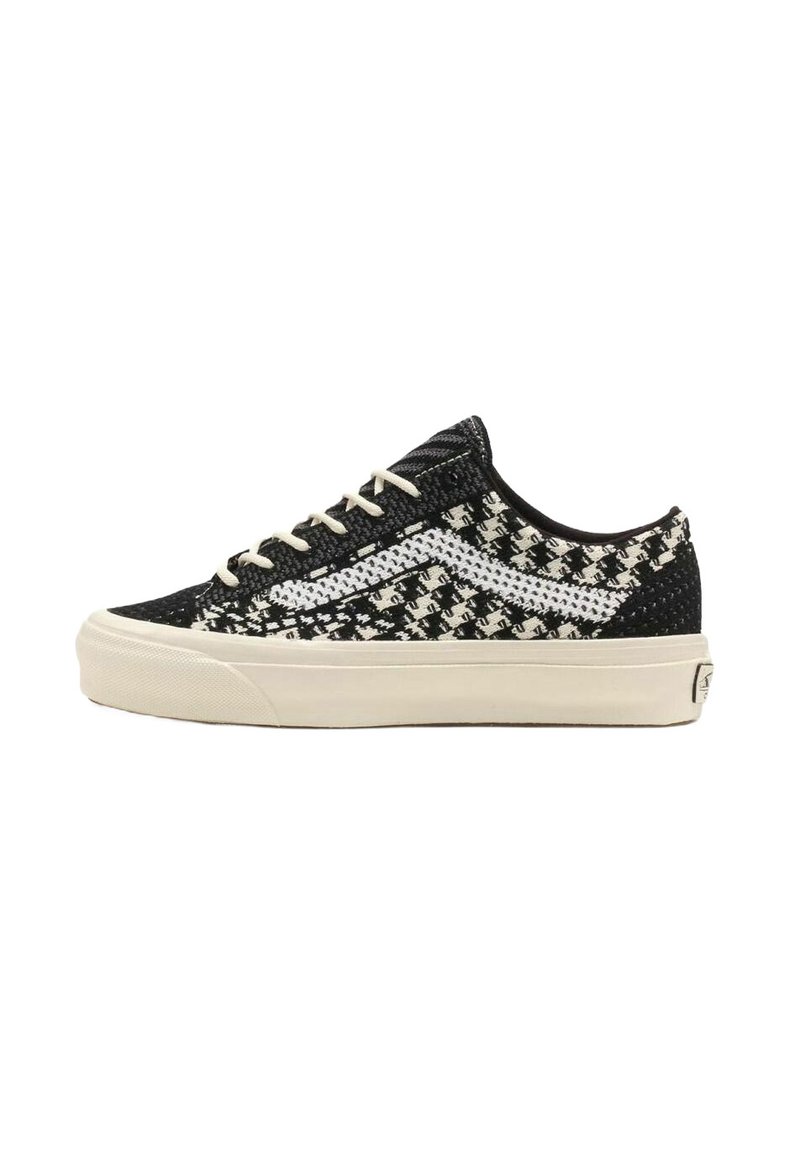 Sneaker a fantasia bianca e nera con tomaia in tessuto texturizzato, strisce laterali bianche e suola in gomma crema. Presenta lacci rotondi e un profilo basso.