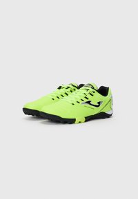 Zapatillas deportivas verde neón con suelas negras, parte superior texturizada y acentos plateados en contraste; cuentan con un diseño con cordones y un collar acolchado.