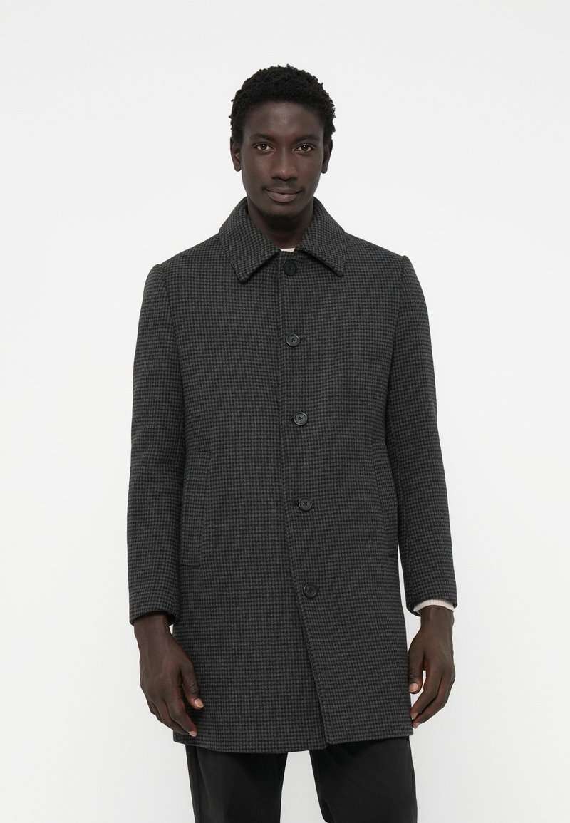 Cappotto grigio a motivo houndstooth con colletto, sei bottoni neri e tasche laterali, caratterizzato da una vestibilità dritta e una tessitura texture.
