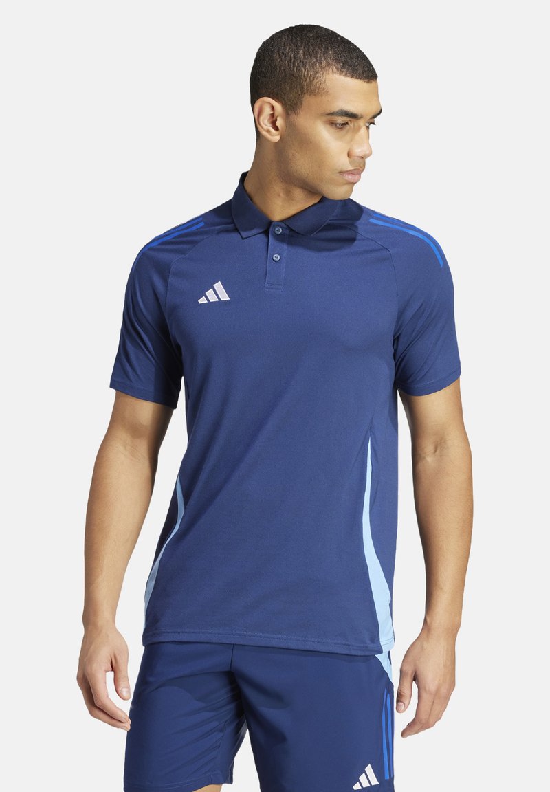 Navy blauwe polo met korte mouwen, gemaakt van vochtafvoerende stof. Voorzien van lichtblauwe zijstrepen en een logo met drie strepen.