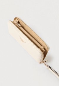 Μπεζ πορτοφόλι με φερμουάρ γύρω γύρω από υλικό με υφή, με χρυσαφί μεταλλικά στοιχεία και πολλαπλές εσωτερικές θήκες για οργάνωση.