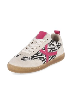 Beige suède sneaker met zwart-wit zebrapatroon, roze accenten, witte veters en een rubberen zool.