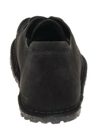 Zwarte suède casual schoen gezien vanaf de achterkant, met zicht op de gestikte hak en de robuuste rubberen zool met gestructureerd profiel.