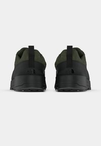 Sneakers nere e verde oliva con parte superiore testurizzata, collo imbottito e suola spessa in gomma. Dotate di una linguetta sul tallone.