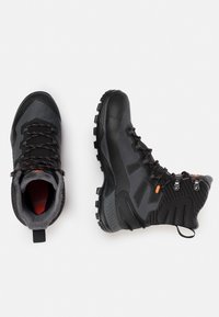 Black hiking boots with a textured fabric upper, rubber toe cap, orange accents, and a rugged sole. Includes a padded collar for comfort.