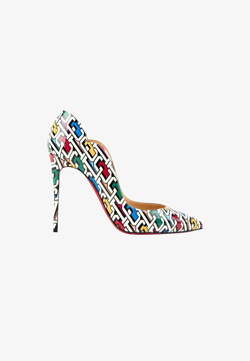 Chaussure à talon haut à bout pointu avec motif géométrique multicolore incluant des formes rouges, bleues, vertes, jaunes et noires sur fond blanc.