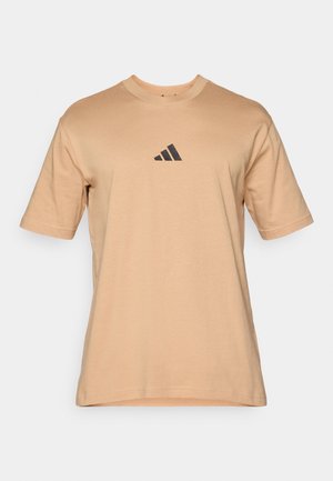 Beige cotton t-shirt with short sleeves, round neckline, and a black triangular logo on the chest. Smooth texture, casual fit.