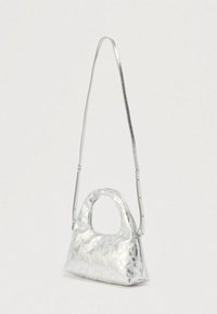 Ασημένια τσάντα χειρός με υφή που διαθέτει μοτίβο διαμαντιού. Περιλαμβάνει κοντή λαβή και μακρύ, ρυθμιζόμενο λουρί ώμου.