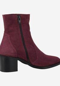 Bottines en daim bordeaux avec une fermeture éclair sur le côté, bout arrondi et un talon noir épais. Détails de couture en relief le long des côtés.