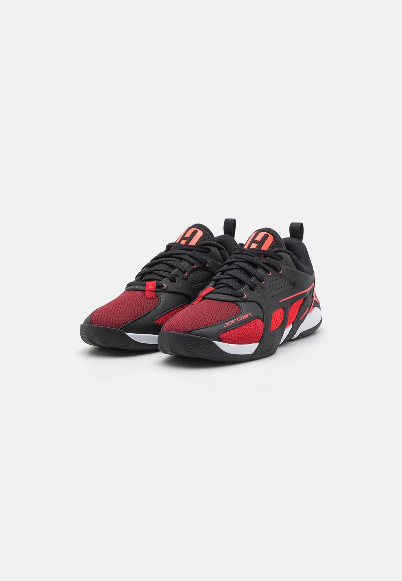 Ein Paar schwarze und rote Jordan-Laufschuhe mit Mesh-Einsätzen, schnürbarem Design und weißen Sohle, die auf einem weißen Hintergrund platziert sind.