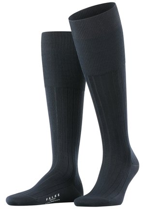 Chaussettes hauteur genou en marine foncé avec texture côtelée, talon et orteil renforcés. Fini lisse avec le logo FALKE sur la semelle.
