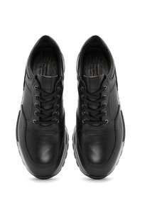 Scarpe nere in pelle con superficie liscia, design con lacci, colletto imbottito e suola grigio a contrasto. Presentano dettagli di cucitura sulla tomaia.