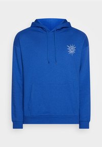 Sweat à capuche bleu en tissu doux, avec une poche avant, une capuche à cordon et un petit motif soleil sur le côté gauche de la poitrine.